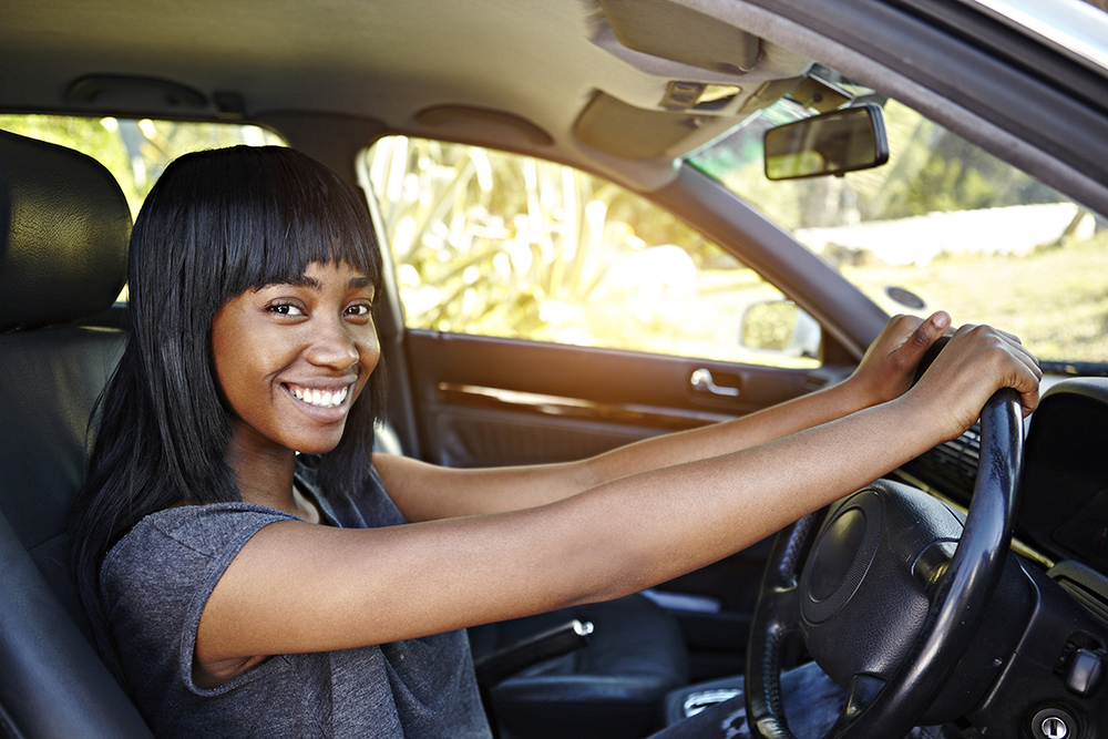 Portrait of young woman driving car